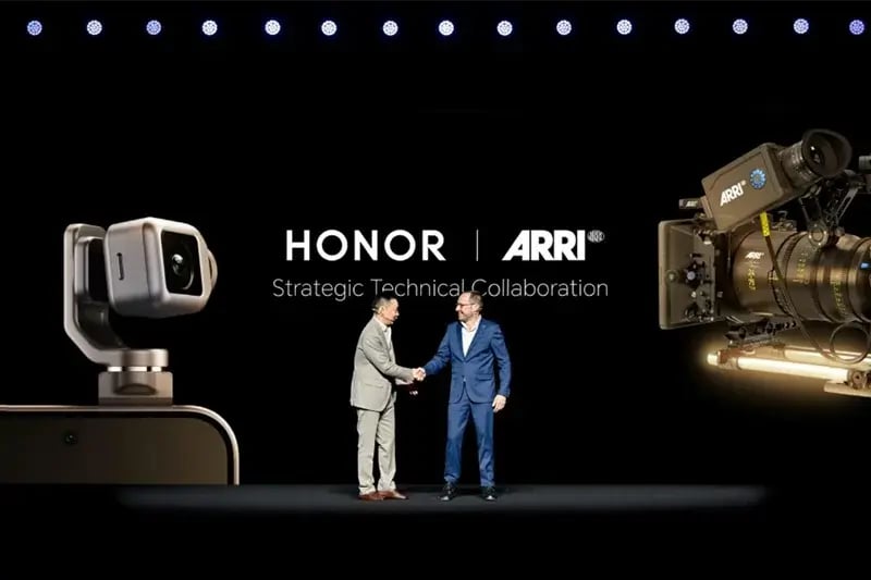Two executives shaking hands on a keynote stage beneath a large screen announcing a strategic technical collaboration between HONOR and ARRI, with product visuals on either side.